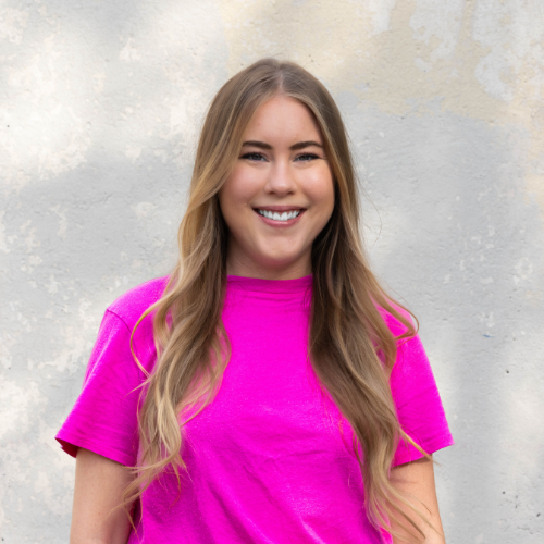 female smiling with long hair and bright shirt