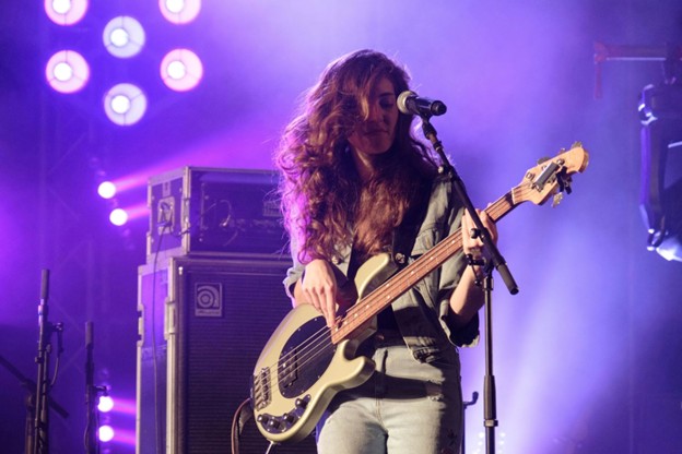 A woman playing guitar on stage