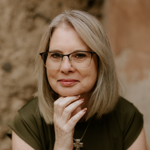 Female with glasses resting chin on hand