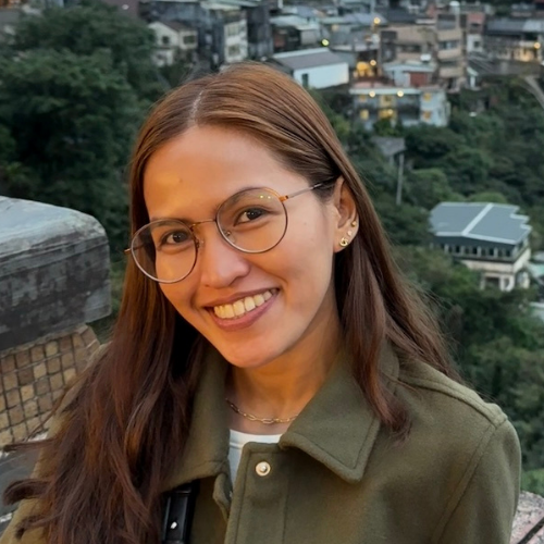 Female with glasses with buildings far in the background